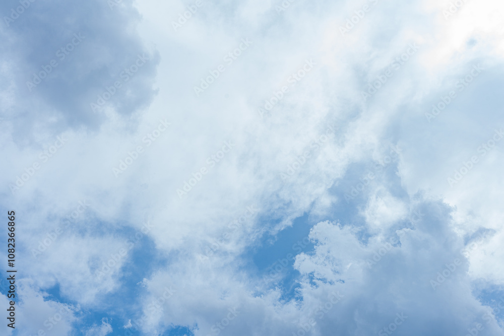 Fluffy white clouds drift across a vast expanse of clear blue sky Fluffy white clouds drift across a vast expanse of clear blue sky
