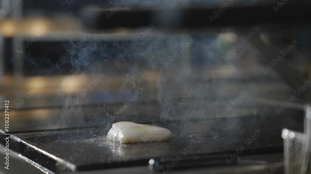 Stir frying some fish meat on a pan in a kitchen of a restaurant Stir frying some fish meat on a pan in a kitchen of a restaurant