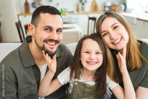 Happy family at home. Mother father children daughter relaxing on sofa indoor. Mom dad parents kid girl relax playing hugging having fun together. Family smiling laughing enjoying tender moment