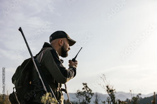Hunter using walkie talkie during hunting trip in the forest