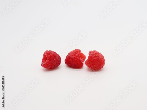 three raspberries on white background