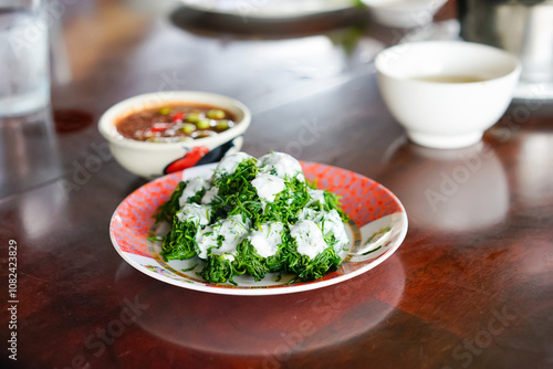 Bai Chakram with coconut cream served with Nam Prik Kapi or Thai shrimp paste chili sauce in the local restaurant. A famous healthy menu in Tambon Yi san, Samut Songkhram. photo