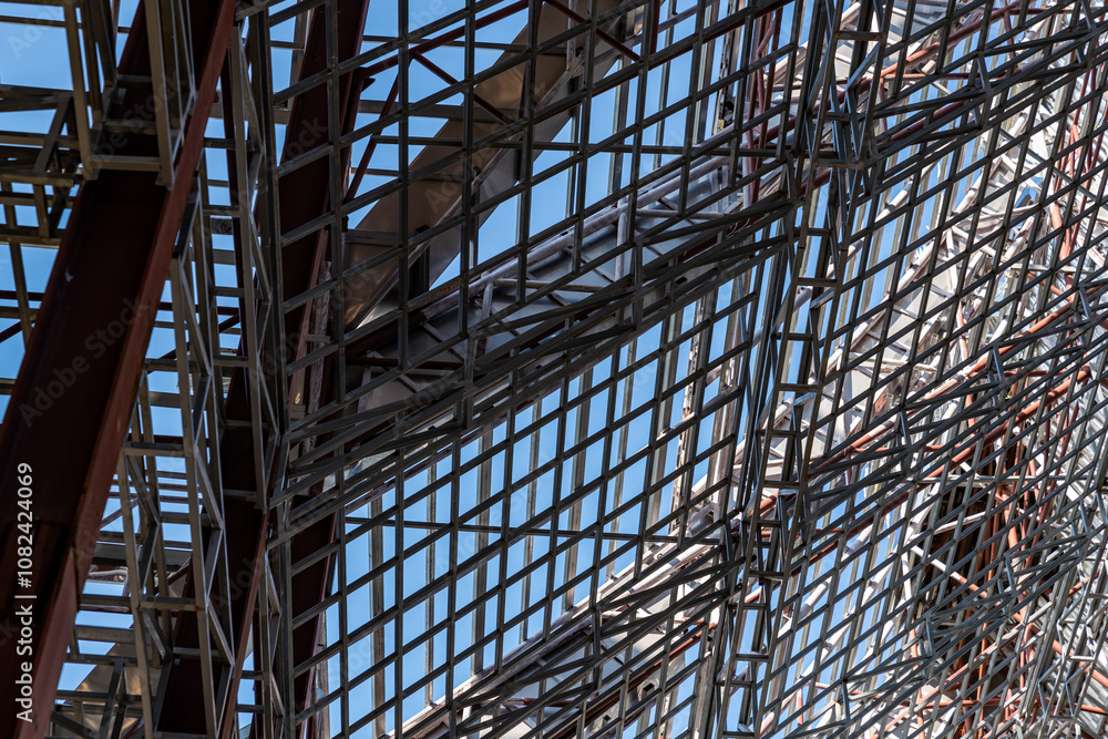 Uprisen angle photo shot of the huge steel roof frame structure detail under construction at the work site. Uprisen angle photo shot of the huge steel roof frame structure detail under construction at the work site.