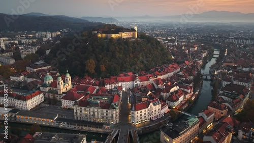 Stunning aerial view of Ljubljana, Slovenia, showcasing charming rooftops and iconic castle at sunset. Ljubljana castle, historic buildings and Ljubljanica river in Slovenian capital 