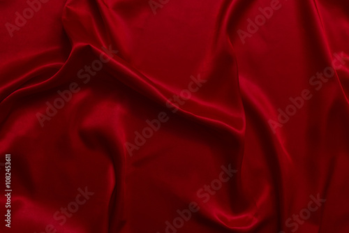 The top view of the red satin surface looks luxurious and beautiful. with sparkling waves Abstract background design copy space Card or banner (blurred or blurry)
