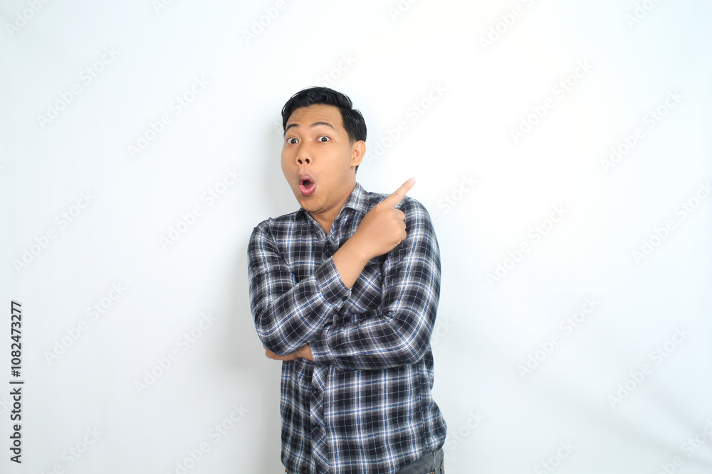 shocked asian man pointing hand with surprised funny expression isolated on white shocked asian man pointing hand with surprised funny expression isolated on white