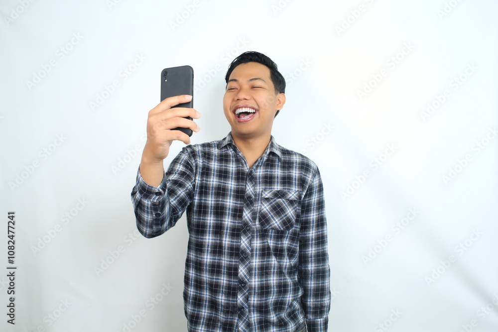 cheerful asian man laughing using smartphone wearing casual shirt isolated on white, joyful male texting on cell phone cheerful asian man laughing using smartphone wearing casual shirt isolated on white, joyful male texting on cell phone