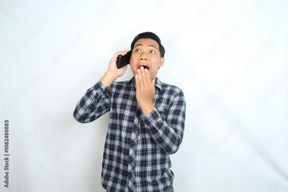 asian man shocked talking on smartphone covering his mouth isolated on white asian man shocked talking on smartphone covering his mouth isolated on white