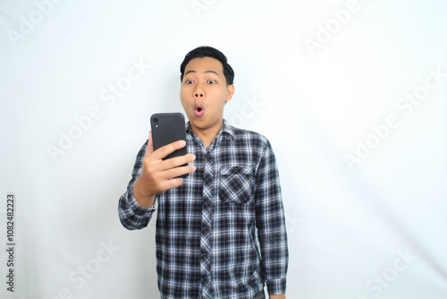 shocked funny asian man read message on mobile phone isolated on white background photo