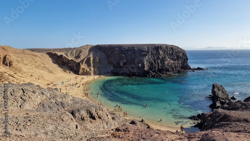 Secluded beach with golden sand and clear turquoise water, surrounded by rocky cliffs and a peaceful atmosphere. Ideal for sunbathers and travelers seeking a serene coastal escape.