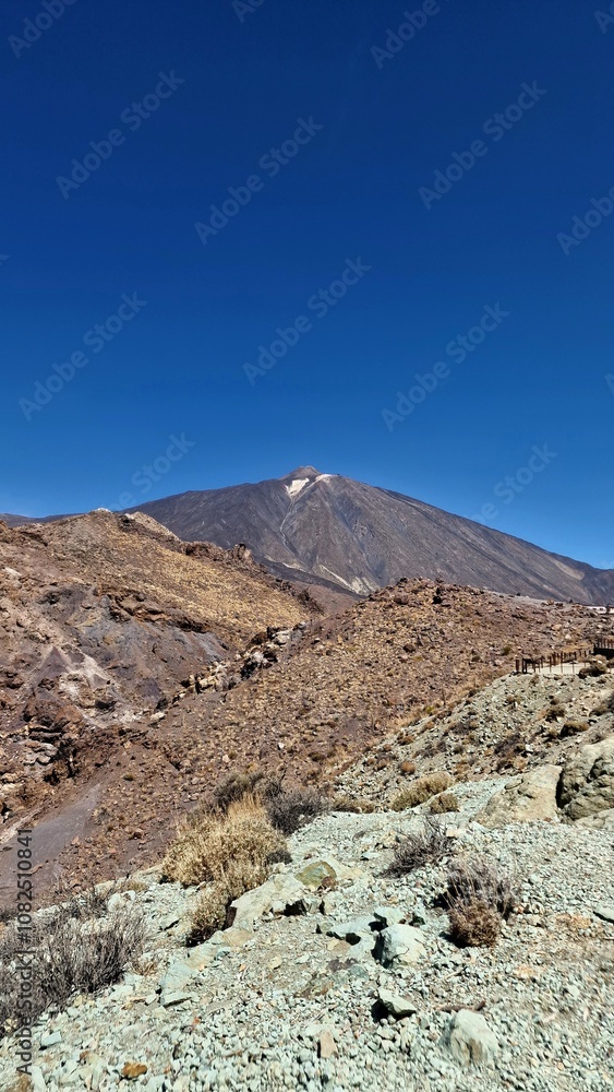 A majestic volcanic mountain peak under a deep blue sky, surrounded by rugged, arid terrain. Perfect for adventure seekers, nature lovers, and outdoor exploration enthusiasts. A majestic volcanic mountain peak under a deep blue sky, surrounded by rugged, arid terrain. Perfect for adventure seekers, nature lovers, and outdoor exploration enthusiasts.