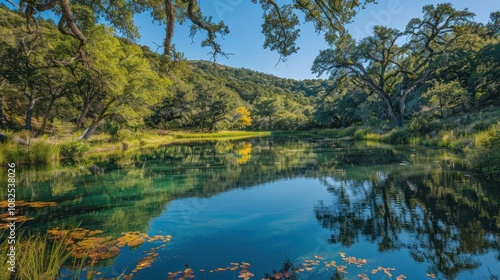 A serene, still lake nestled in a lush green valley with clear blue water, reflecting the sky and trees.