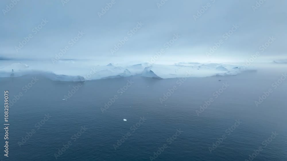 Moody view of huge icebergs floating at the horizon in the icefjord in the Disko Bay near Ilulissat in West Greenland. Epic scene in the arctic with dramatic sky Moody view of huge icebergs floating at the horizon in the icefjord in the Disko Bay near Ilulissat in West Greenland. Epic scene in the arctic with dramatic sky