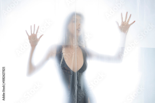 Mysterious Woman Behind Frosted Plastic Sheet in Abstract Studio Setting