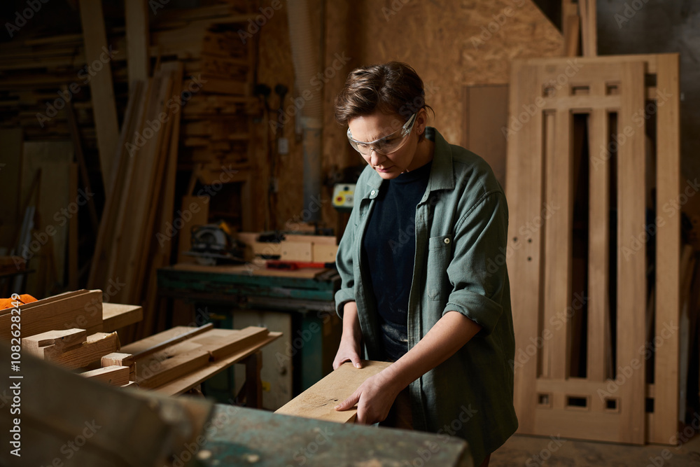 A skilled carpenter works diligently with wood, shaping materials in a welcoming workshop filled with tools. A skilled carpenter works diligently with wood, shaping materials in a welcoming workshop filled with tools.