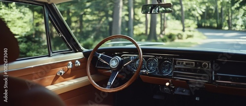 The vintage car's interior reveals a classic steering wheel and dash, basking in warm sunlight as the journey unfolds down a scenic wooded road.