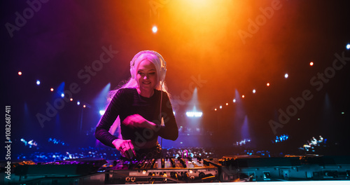 DJ Mixing Hit Songs on Mixing Decks. Empowering Young Music Producer Performing a Live Concert, Dancing, Having Fun, Entertaining a Crowd of Electronic Music Fans Under Colorful Neon Lights photo