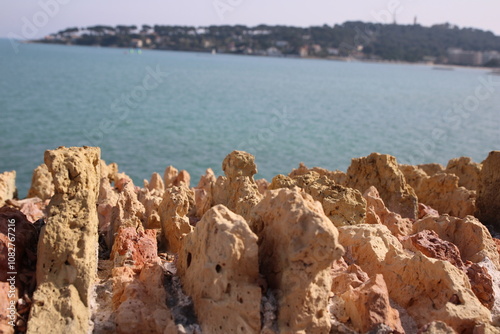 Curious rock formation in front of the dark blue Mediterranean Sea on a sunny day in Antibes, on the Côte d'Azur, France.