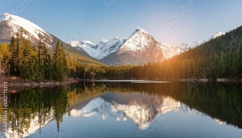 Serene Lake Nestled Between Snow-Capped Peaks and Lush Forests, Reflecting the Sunshine and Surrounding Scenery on Its Glassy Surface During Early Morning