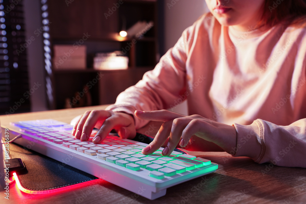Fototapeta premium Girl using computer keyboard at wooden table indoors, closeup