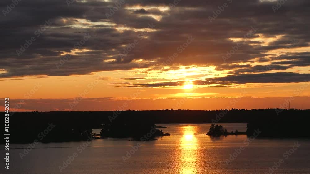 A tranquil sunset paints the sky in vibrant hues as the sun descends over the lake, illuminating the water and surrounding islands, creating a calming natural landscape during evening. A tranquil sunset paints the sky in vibrant hues as the sun descends over the lake, illuminating the water and surrounding islands, creating a calming natural landscape during evening.