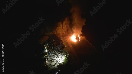 crowd gathered around bonfire fair tain scotland flames smoke create families festivities laughter circling aerial shot mesmerizing atmosphere community event gathering celebration  photo