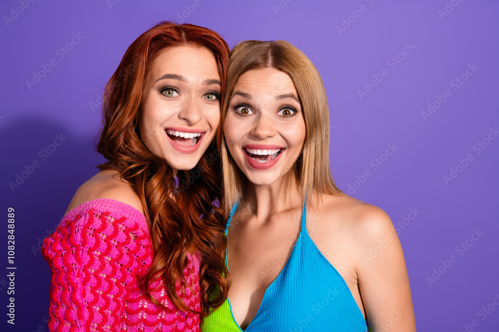 Portrait of two nice stunning girls open mouth empty space ad isolated on purple color background Portrait of two nice stunning girls open mouth empty space ad isolated on purple color background
