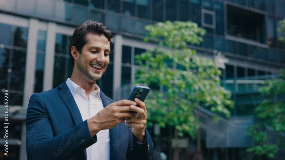 Handsome Businessman Stands Outside near Office Building, Texting and Receiving Good Messages. Handsome Businessman Stands Outside near Office Building, Texting and Receiving Good Messages.