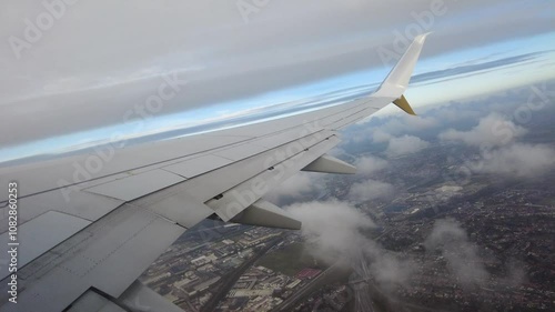 airplane departs flying over clouds city visible underneath from passenger's wing scene budget travel tourism view departure aerial skyline aviation perspective flight experience 
