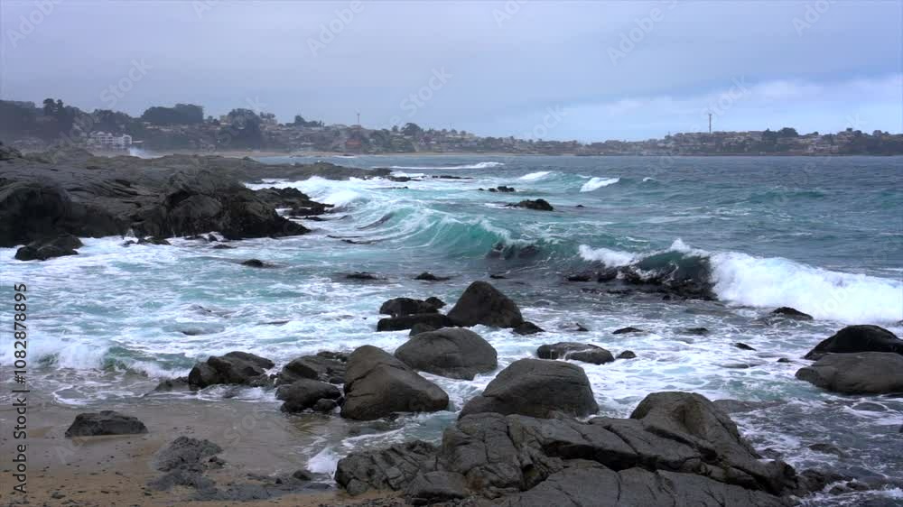Turquoise waves crash against a rocky coastline under a cloudy sky, showcasing the power and beauty of nature Turquoise waves crash against a rocky coastline under a cloudy sky, showcasing the power and beauty of nature