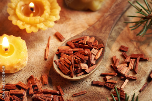 Red sandalwood chips on a spoon with beeswax candles photo