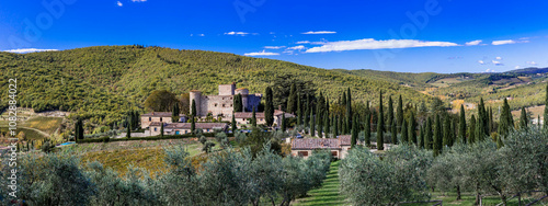 Italy, Tuscany landscape with cypresses. Scenic  medieval castle and hotel  surrounded by vineyards in autumn colors - Castello di Meleto in Chianti region. photo