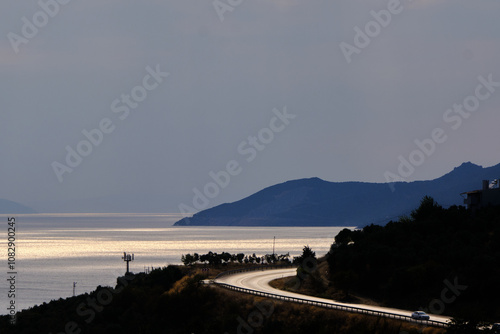 S curve asphalt road and sea and mountain background reflection of sun lights.