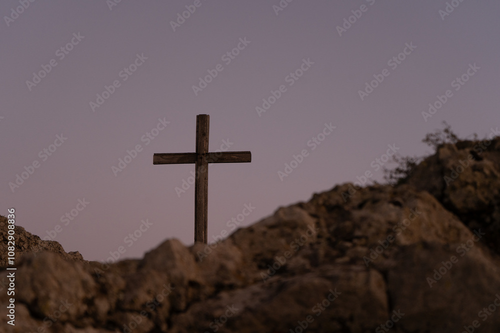 Christian cross on top of a mountain in Georgia against the backdrop of a picturesque fiery sunset Christian cross on top of a mountain in Georgia against the backdrop of a picturesque fiery sunset
