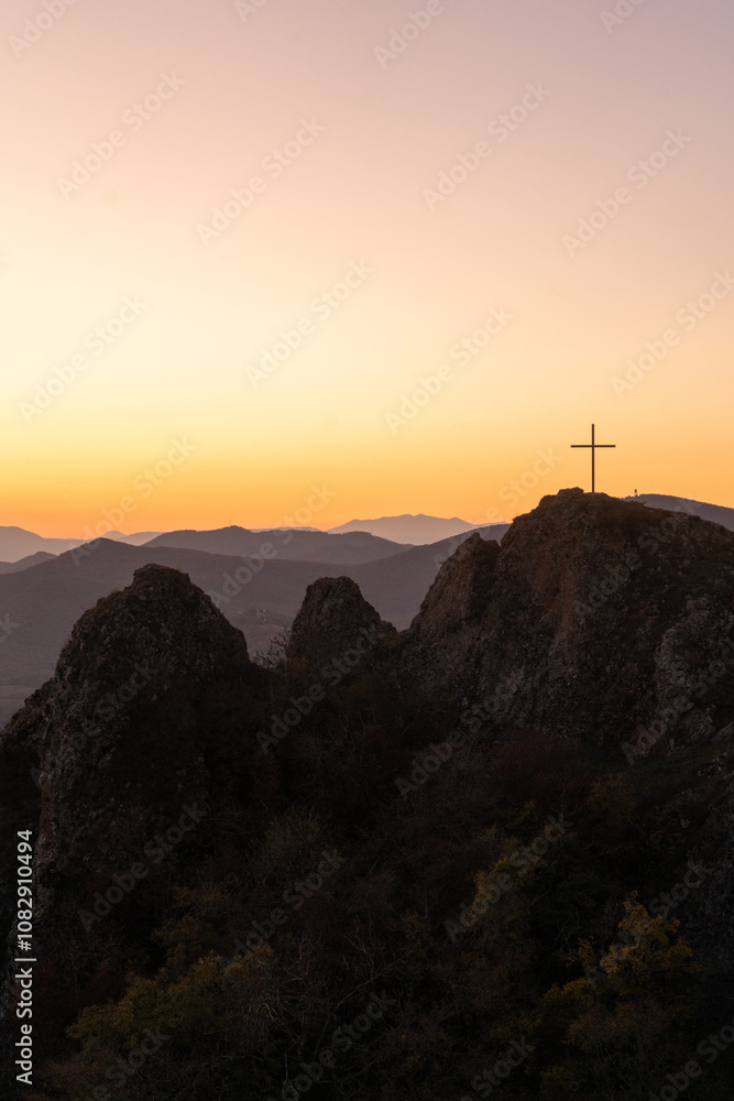 Christian cross on top of a mountain in Georgia against the backdrop of a picturesque fiery sunset Christian cross on top of a mountain in Georgia against the backdrop of a picturesque fiery sunset