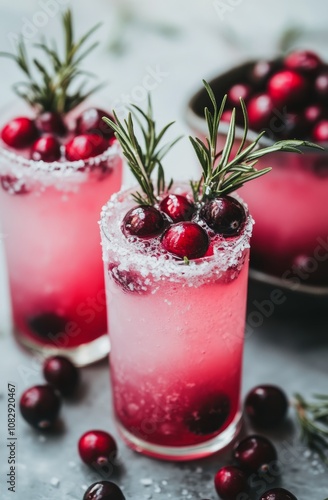 Refreshing cranberry cocktails garnished with rosemary and cherries for festi...