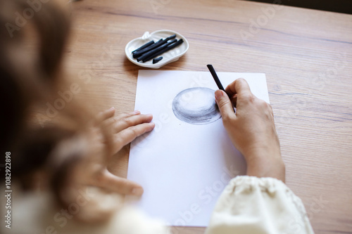 Artist Sketching Sphere with Charcoal on Paper photo