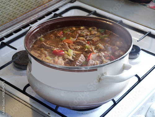 oriental soup kharcho of beef, rice, tomatoes, tkemali plum puree, fried onion and cilantro. steam over boiling soup in big open pot on gas stove