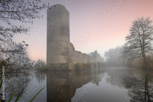 Ruins of a castle. Landscape shot in autumn. Defensive structure in a lake. Misty landscape in the morning at the historical sight in Morbach, Baldenau castle ruins, Rhineland-Palatinate, Germany photo