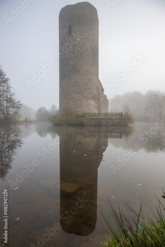 Ruins of a castle. Landscape shot in autumn. Defensive structure in a lake. Misty landscape in the morning at the historical sight in Morbach, Baldenau castle ruins, Rhineland-Palatinate, Germany photo