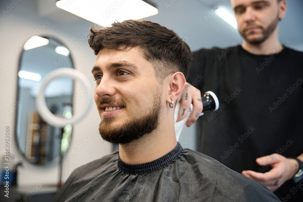 Fototapeta premium Professional groomer uses big brush to apply white powder