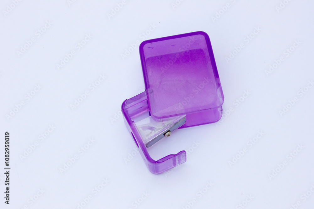 A photo of a purple pencil sharpener standing alone on a white background. A photo of a purple pencil sharpener standing alone on a white background.