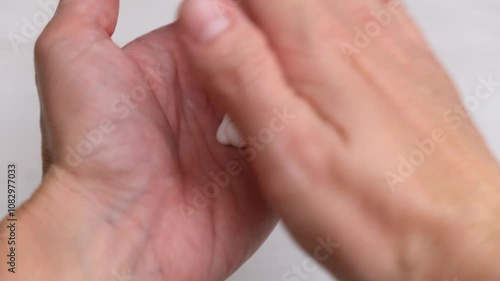 Woman applying nourishing cream on hands close up