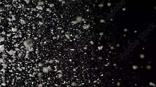 A dense heavy blizzard snowstorm VFX insert in slow-motion on black screen. Black screen Christmas snowstorm. Particles swirling moved by wind. Snow is moving through space. Snowstorm on black. photo