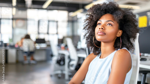 Young African American woman relaxing at her office desk, looking upward with a thoughtful expression. Free Download Young African American woman relaxing at her office desk, looking upward with a thoughtful expression. - GFXLoad