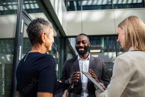 Business professionals discussing project outside office building photo