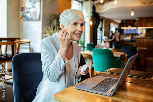 Senior businesswoman using laptop in cafe photo