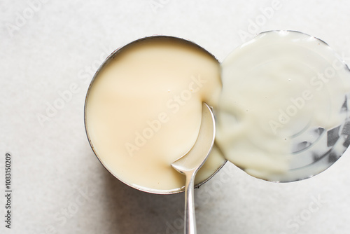 Foto Overhead view of an opened tin of condensed milk with the lid, top view of canne