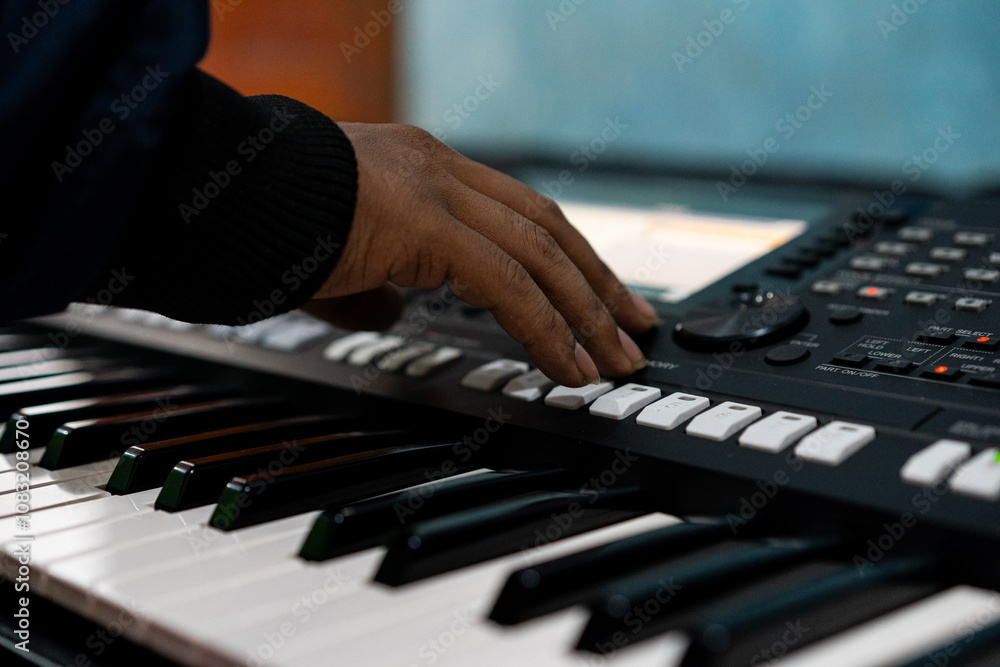 Fototapeta premium close up portrait of male hands playing a keyboard instrument.