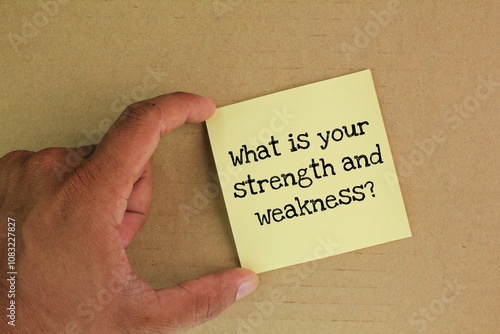 colored paper with the question What is your strength and weakness? the concept of self-motivation photo